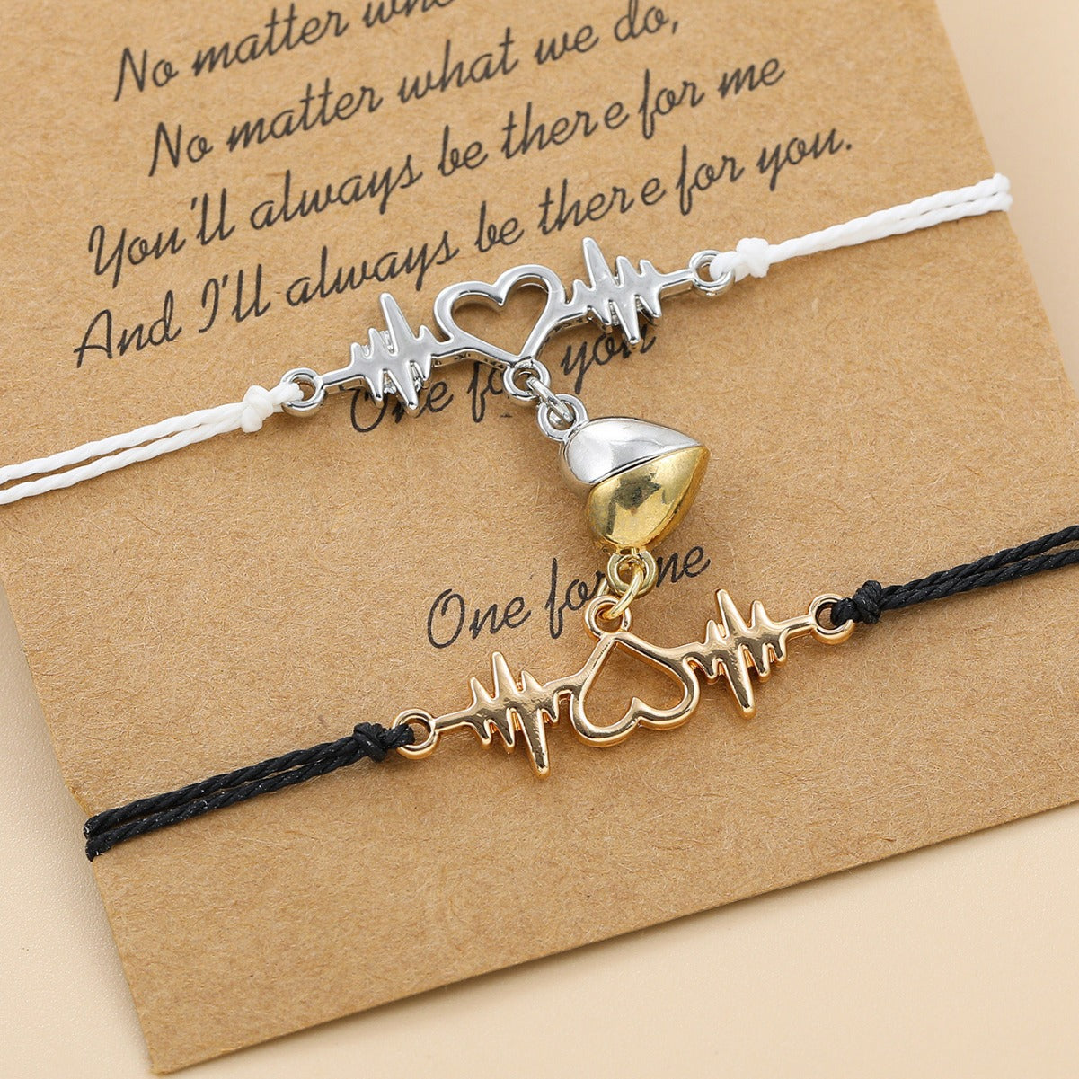 Two bracelets with heart and heartbeat charm on a brown card with text.