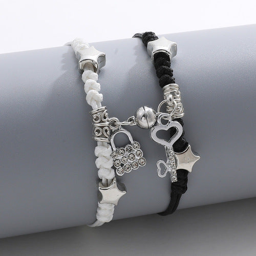 Two bracelets with star and lock charms on a gray surface