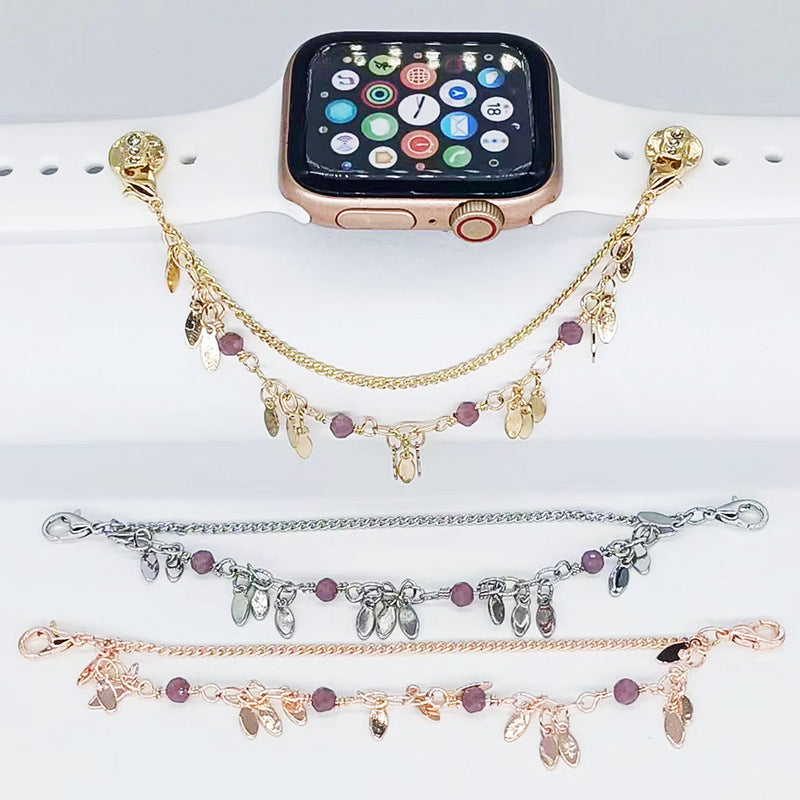 Smartwatch with gold, silver, and rose gold charm bracelets on a white surface
